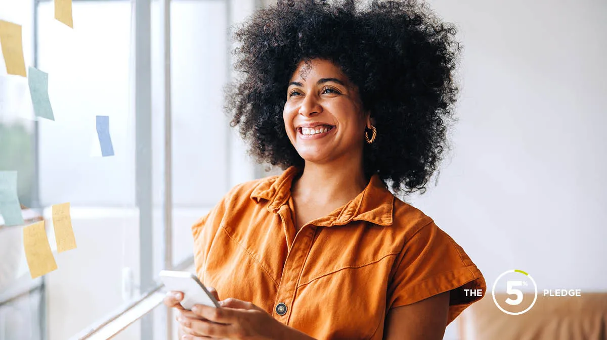 Young worker sitting at her desk with a big smile looking very happy 