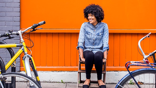 womansmiling-orangeback-bluebike