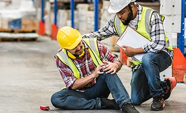 injured warehouse employee being helped by colleague