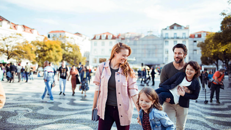 mum and dad with two young children in a historic town open square