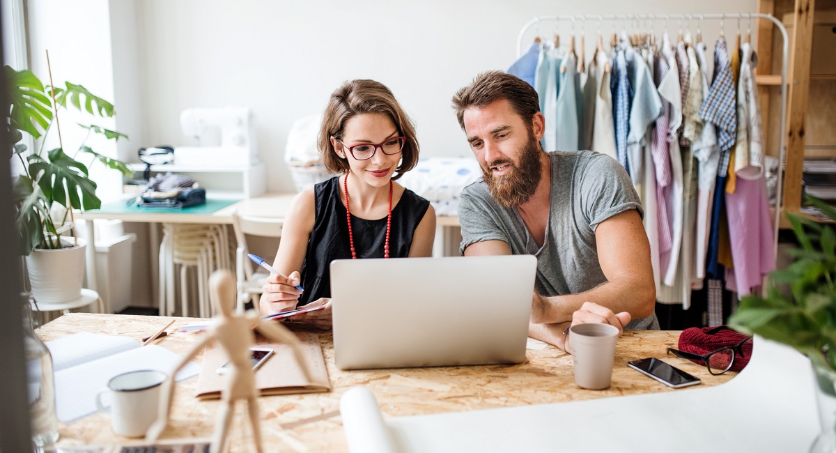 A man and a woman reading something in their laptop