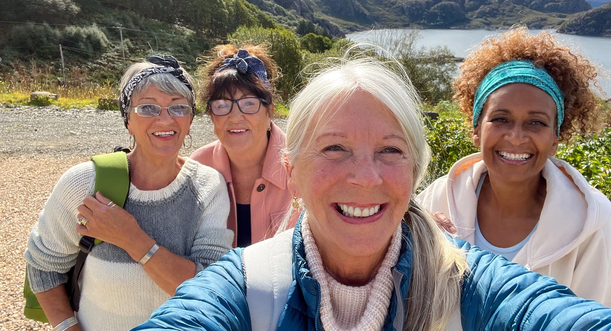 Four women in their 50s taking a selfie in the countryside