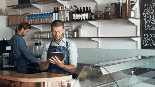 eigenaar koffiebar kijkt op zijn tablet