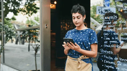 empleada de una cafetería comprobando su tablet