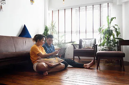 young-couple-sitting-on-the-floor-looking-at-a-laptop