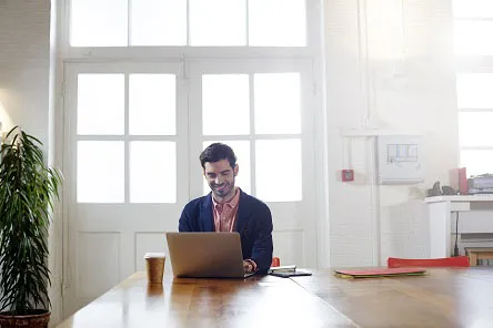 Mann, der mit seinem Laptop arbeitet