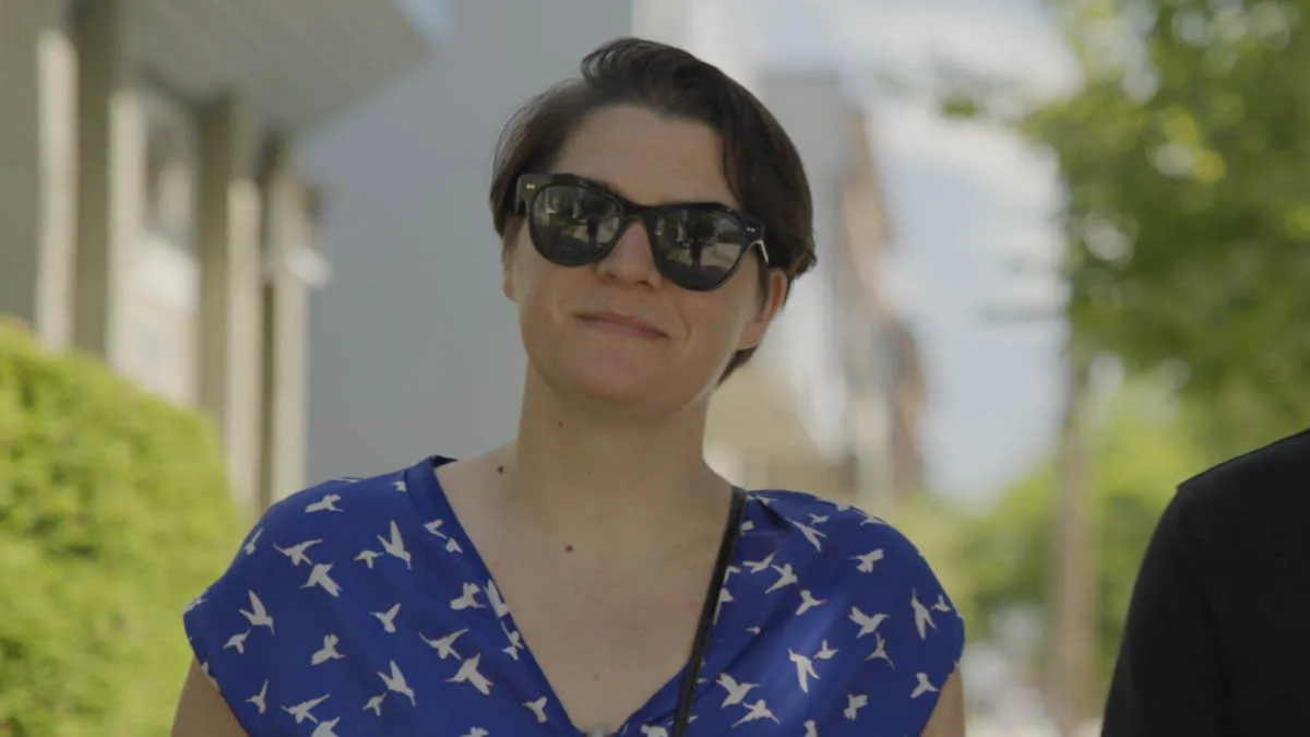 Australian expat Simone wearing sunglasses, smiling in the outdoors