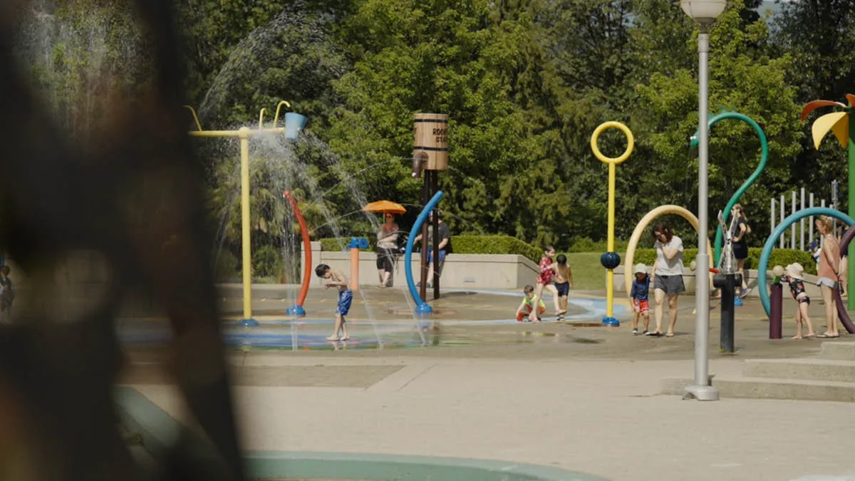 A playpark with water features being enjoyed by young children in Canada