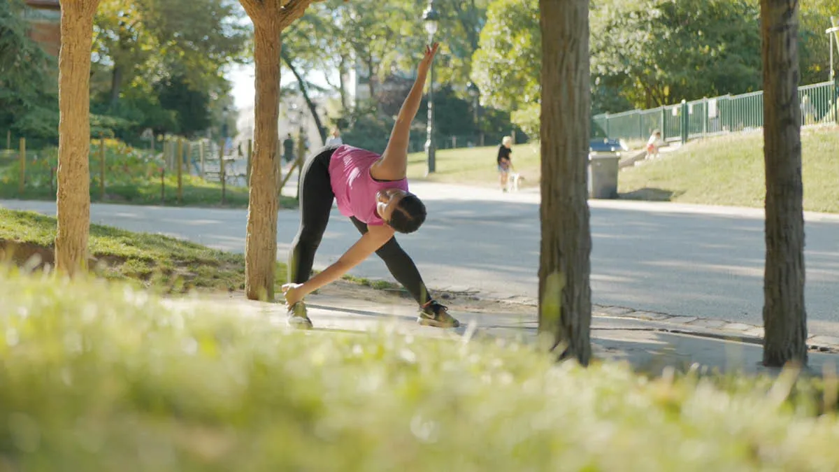 Japanese expat Akiko performing stretching exercises in a French park 