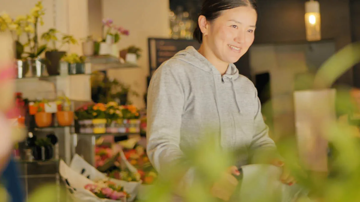 Japanese expat Akiko smiling inside a florists shop in Paris