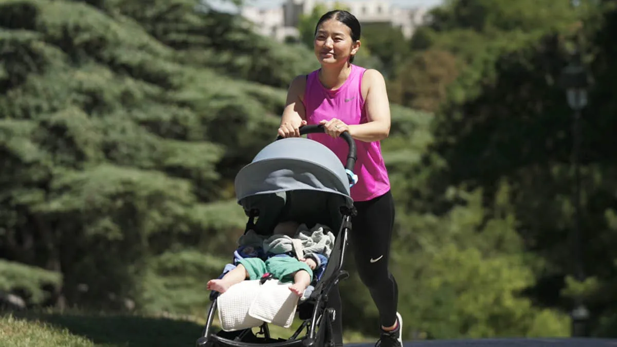 Japanese expat Akiko pushing her baby son in a pram in a Parisian park