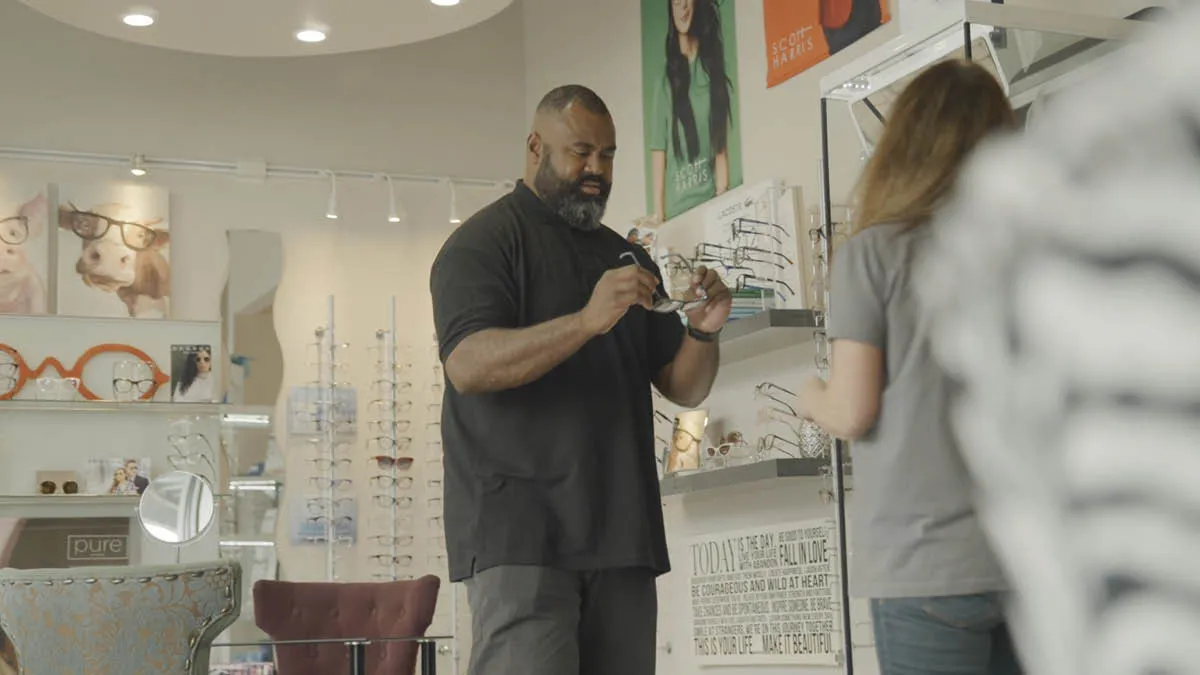 Fijian expat Pate trying on glasses in an opticians in Seattle