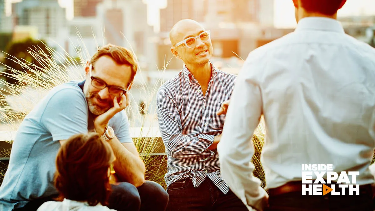 A group of relaxed looking people chatting in an outside setting