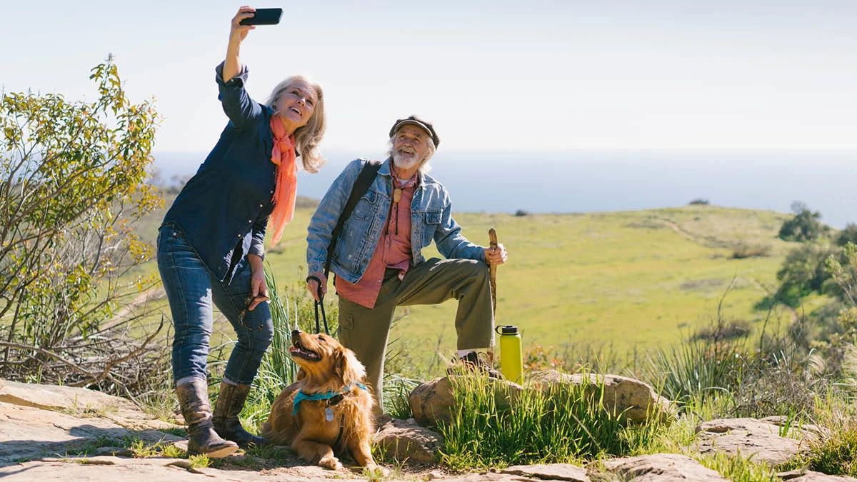 retired couple in the countryside with their dog taking a selfie