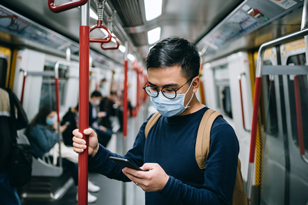 Man commuting to work by train while wearing a face mask