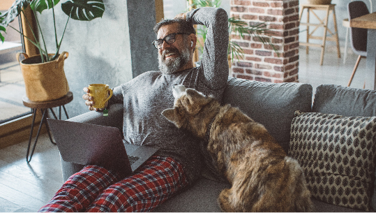 man looking happy, watching at his computer screen in his living room